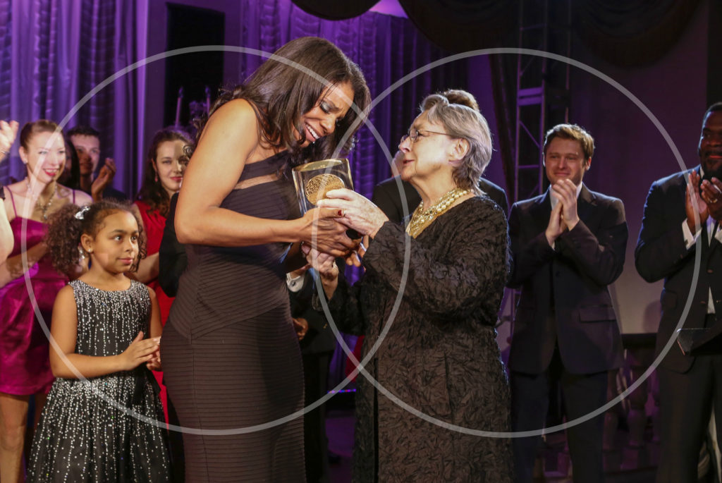 Audra McDonald Receives Drama League Award against a purple curtain